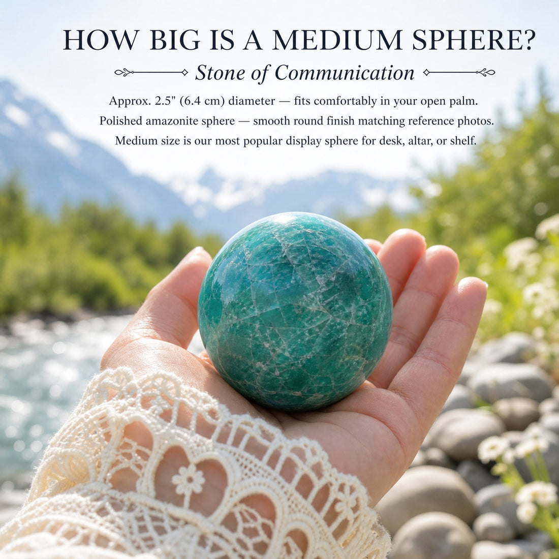 A medium amazonite sphere resting in an open palm beside a mountain river