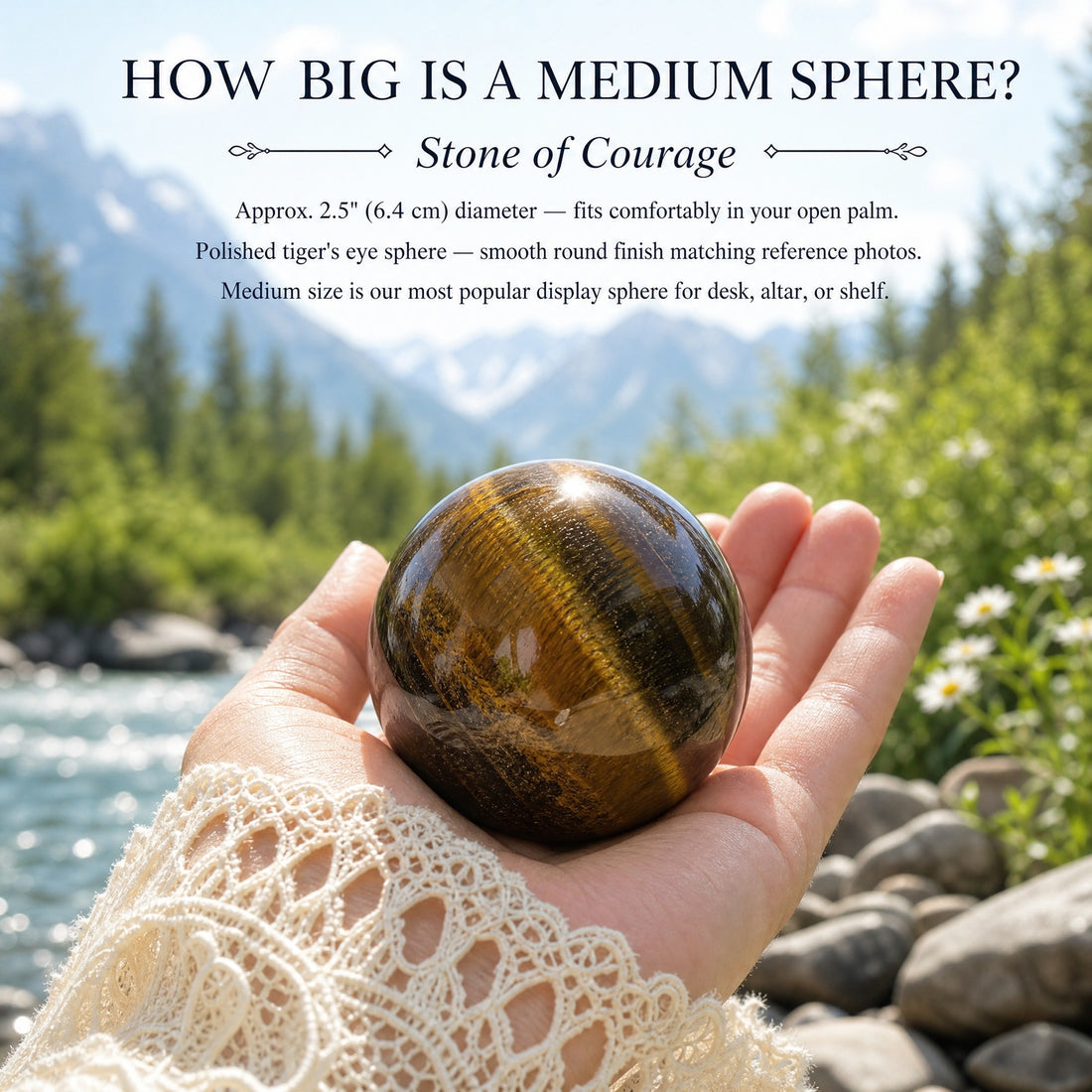 A polished tiger's eye sphere resting in an open palm beside a mountain stream
