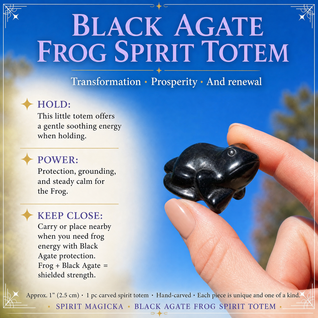 The black agate frog totem held between finger and thumb against a blue sky, showing its one-inch size