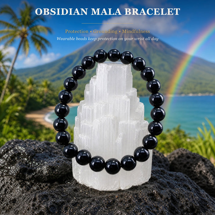 An obsidian mala bracelet of round polished beads displayed on a selenite tower