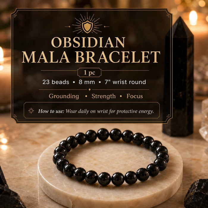 A glossy black obsidian bead bracelet on a marble stand