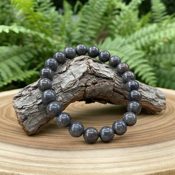 Yooperlite round bead mala bracelet draped over driftwood