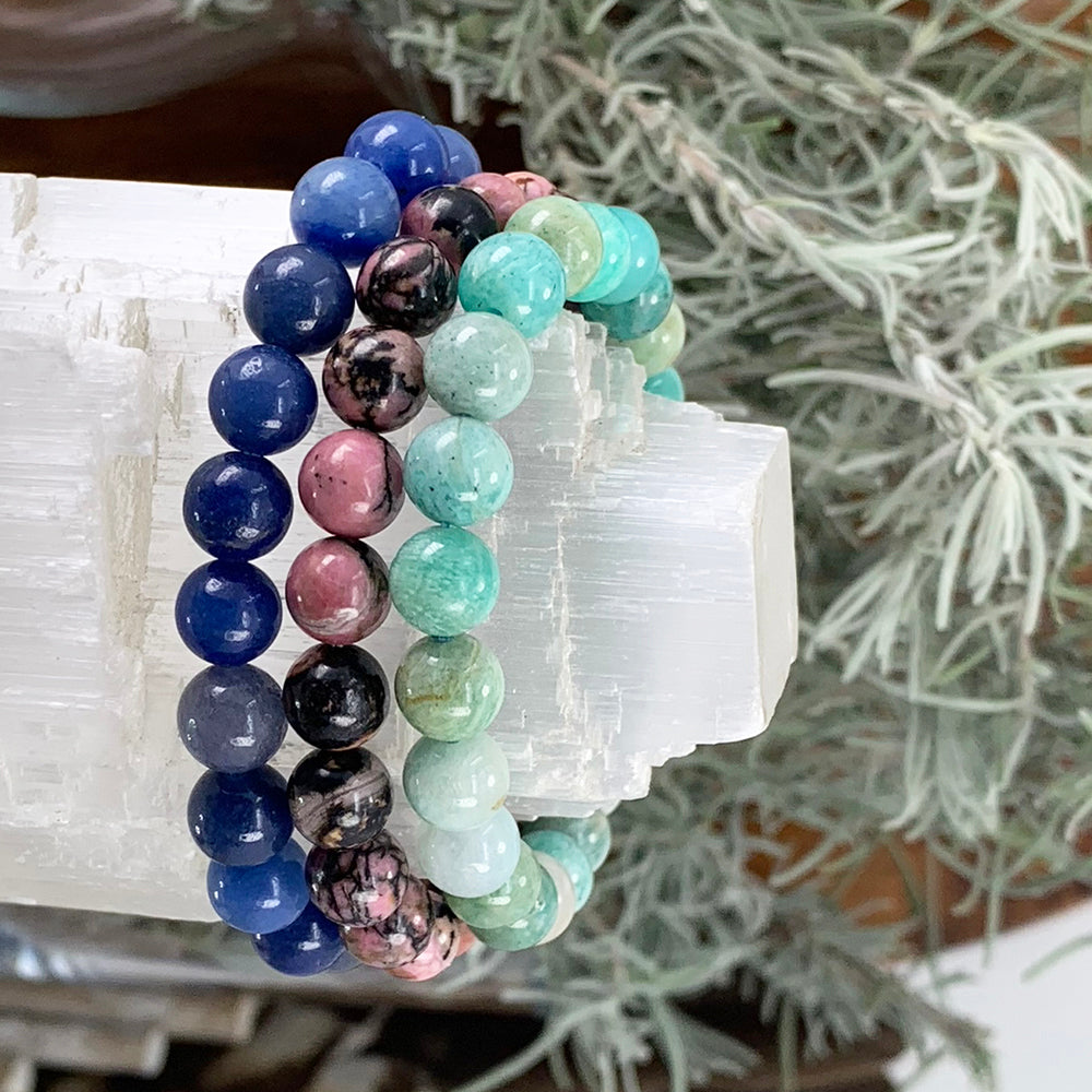 Blue Aventurine, Rhodonite and Amazonite bracelets stacked together on a selenite log