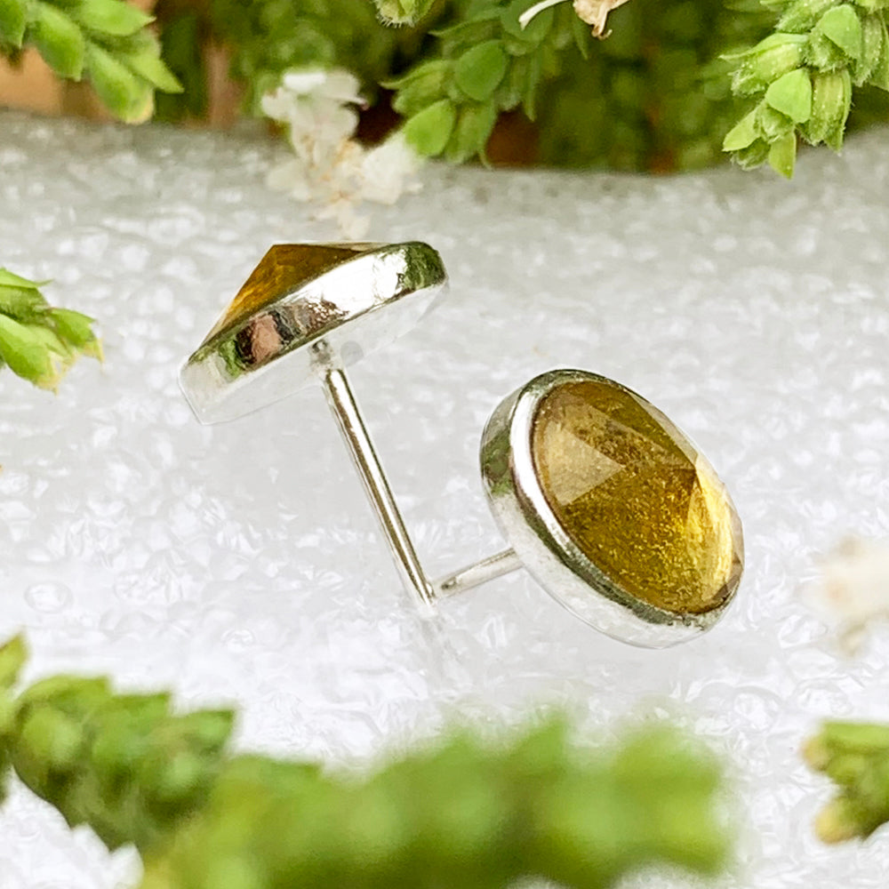 Side view of the two amber studs showing their faceted stones, silver bezels and posts