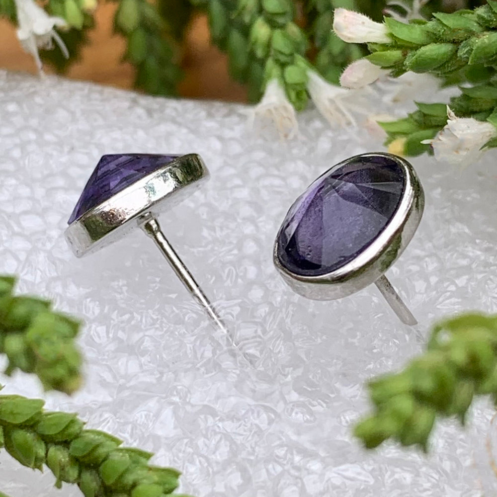 Side view of the two amethyst studs showing their faceted stones, silver settings and posts