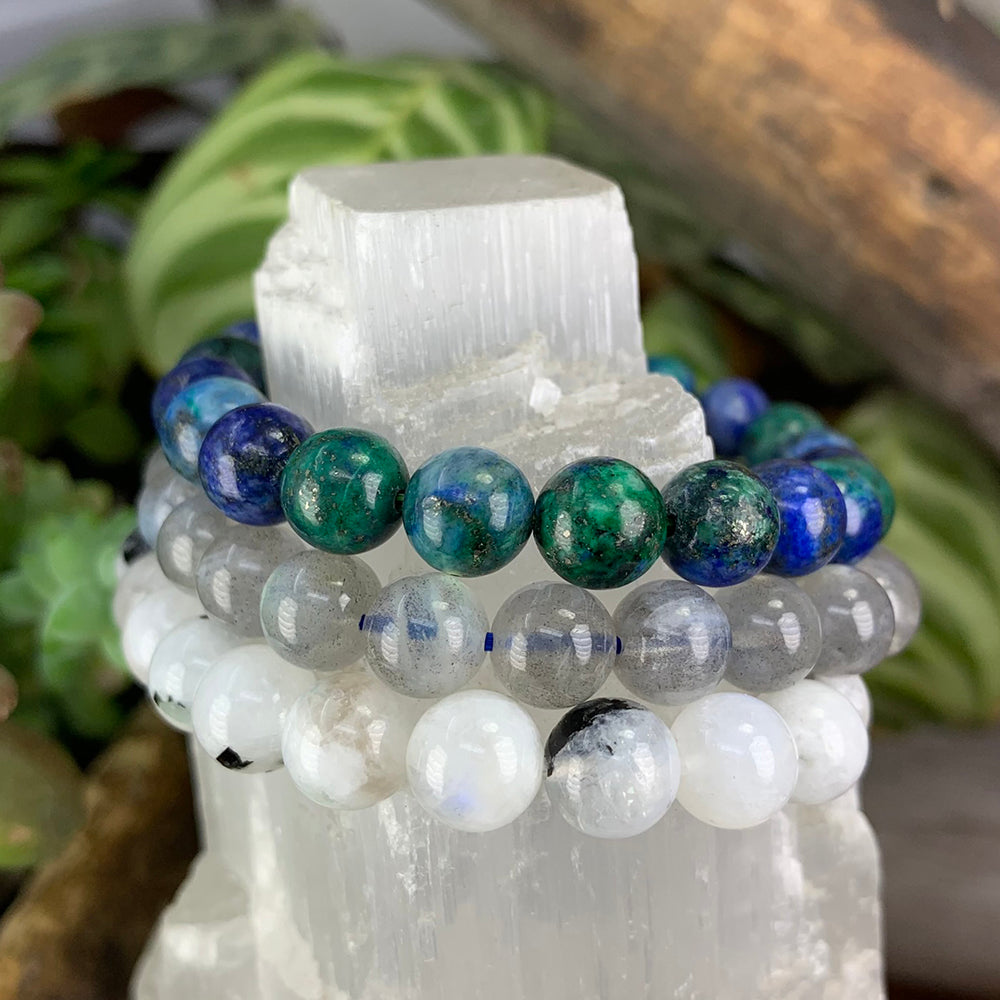 Azurite, grey moonstone and rainbow moonstone bead bracelets stacked on a selenite tower