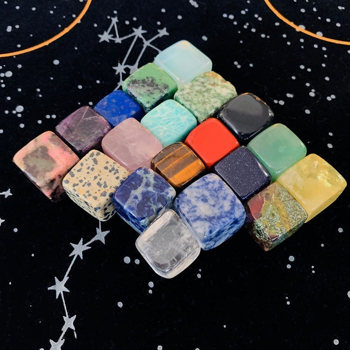 Colourful tumbled crystal cubes lined up on the starry velvet cloth