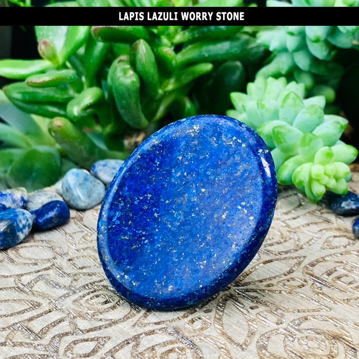 A flat oval lapis lazuli worry stone in solid deep blue with fine golden flecks