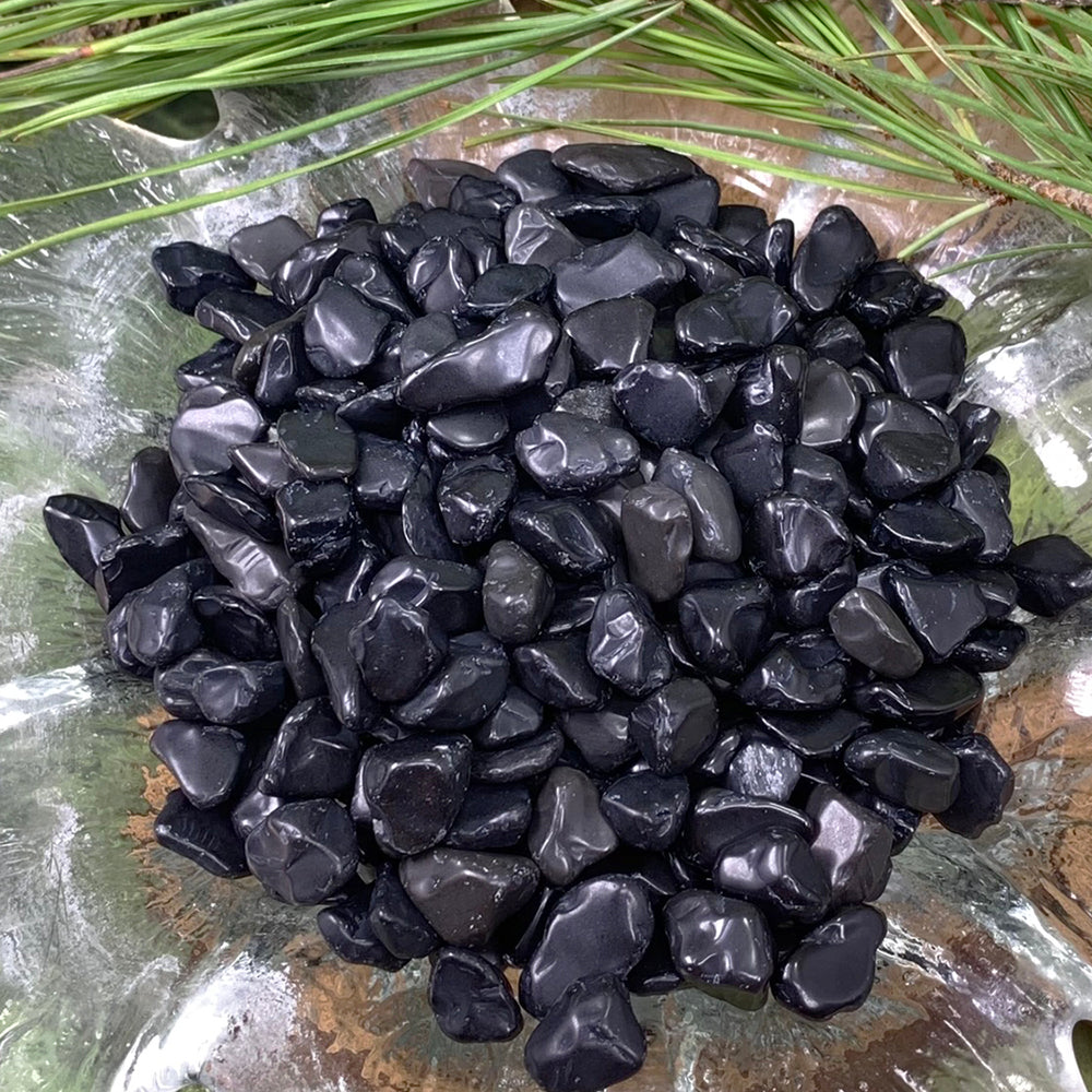 Close-up of polished black obsidian mini gemstones showing their smooth, glassy surfaces