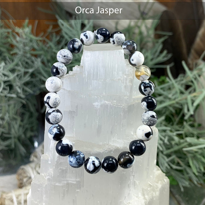 Orca Jasper bracelet with black and white swirled beads, displayed on a selenite tower