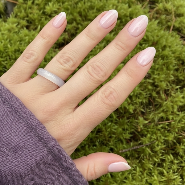 The pale pink agate band ring worn on a finger
