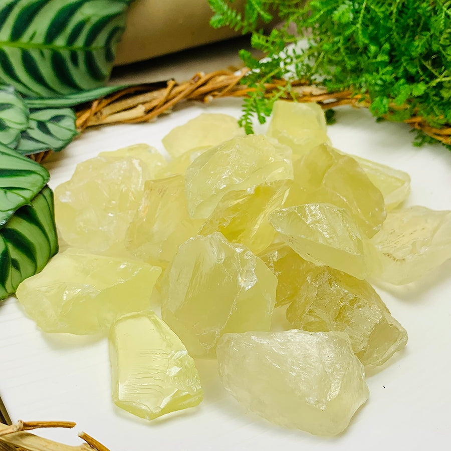 A pile of rough lemon citrine pieces in pale lemon tones, each a different shape